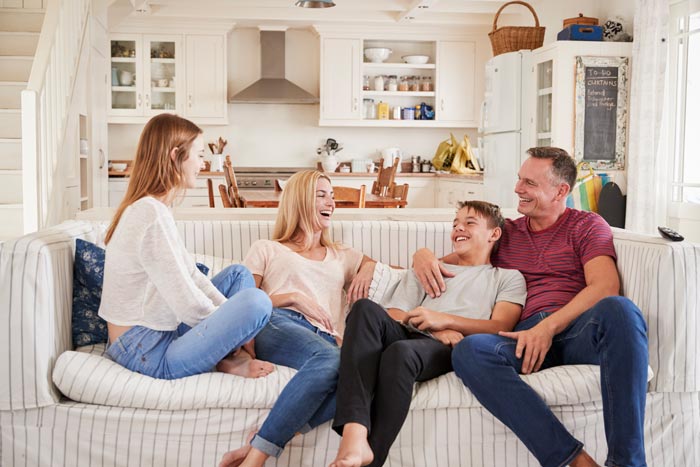 family laughing and relaxing on couch